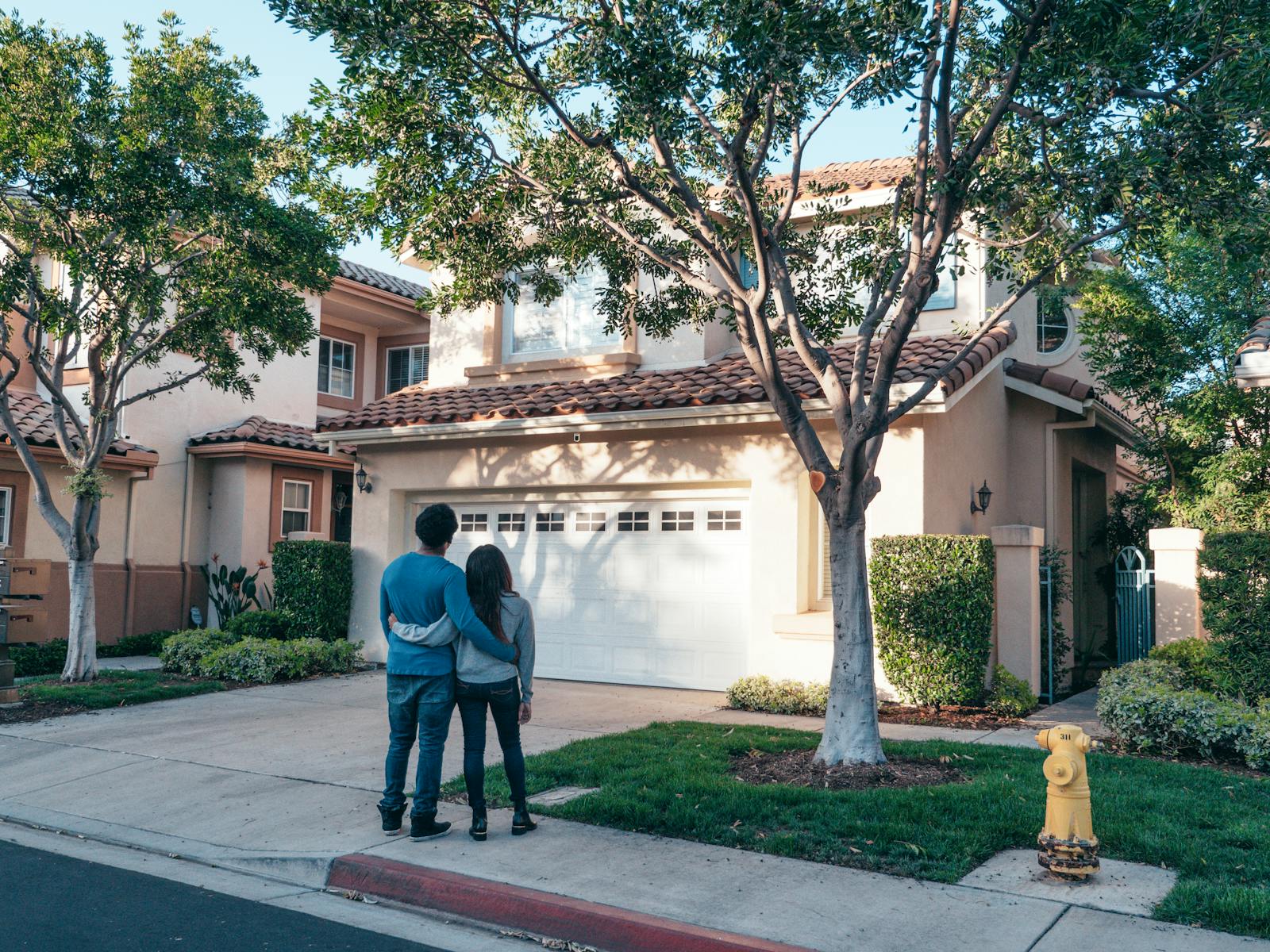 Couple Standing In Front of their House, home insurance